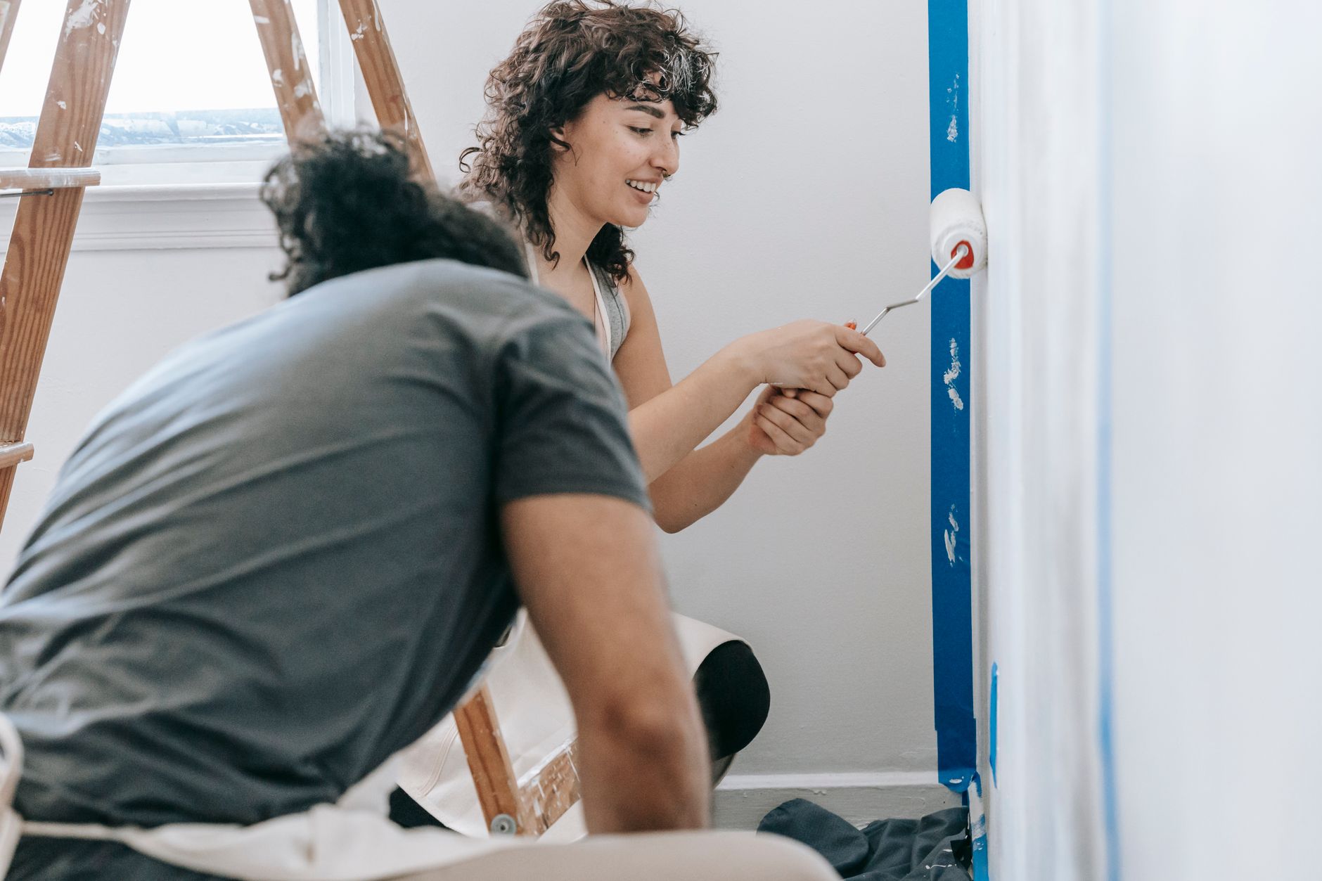 Happy couple painting their new apartment with smiles and enthusiasm in Santa Monica, CA